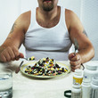 Overweight man eating plate full of pills