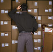 Confused businessman standing with boxes