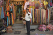 Mixed race man standing in Indian fabric market store