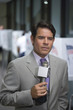 Serious newscaster holding microphone