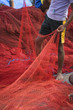 Barefoot boy standing with red fishing nets