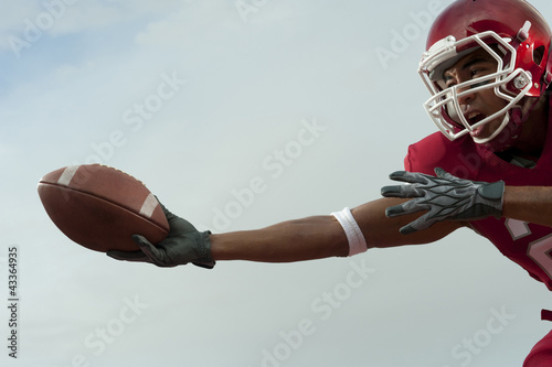 Photo: Black football player catching football Black football player catching football