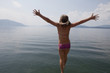 Photo: Caucasian girl in bikini jumping into lake Caucasian girl in bikini jumping into lake