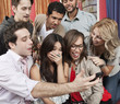 Friends looking at cell phone at party