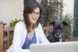 Caucasian woman and dog looking at laptop