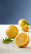 Whole and sliced oranges on table cloth