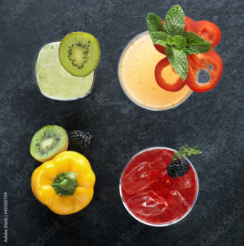Photo: Array of alcoholic beverages with kiwi, bell pepper and blackberry garnishes, top view Array of alcoholic beverages with kiwi, bell pepper and blackberry garnishes, top view