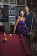 Glamorous couple playing pool in bar