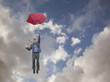 Mixed race businessman holding umbrella and falling through clouds