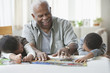 Grandfather and grandchildren putting a puzzle together