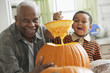 Grandfather and grandson carving a pumpkin