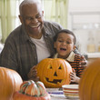 Grandfather and grandson carving a pumpkin