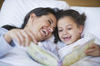 Hispanic mother reading book to daughter