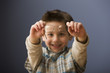 Caucasian boy holding eyeglasses