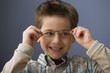 Caucasian boy putting on eyeglasses