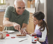 Grandfather and granddaughter making sandwiches
