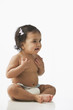 Hispanic baby girl sitting on floor