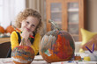 Caucasian girl painting pumpkins
