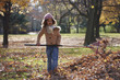 Black girl raking autumn leaves
