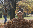 Black family raking autumn leaves