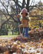 Black girl raking autumn leaves