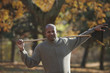 Black man holding rake in autumn