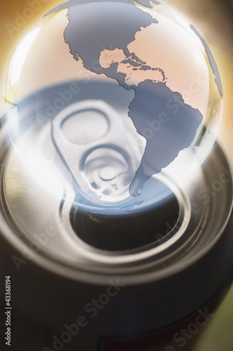 Photo: Transparent globe hovering over aluminum can Transparent globe hovering over aluminum can