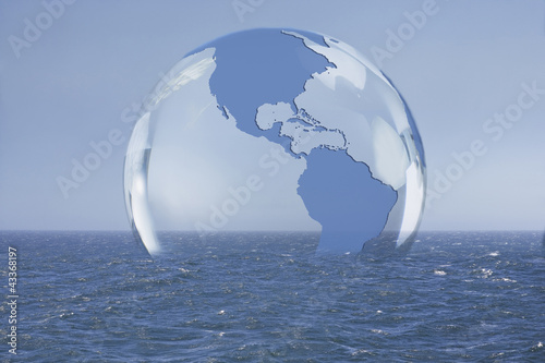 Photo: Transparent globe floating on ocean Transparent globe floating on ocean