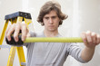 Caucasian man measuring with measuring tape