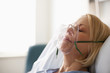 Caucasian patient laying in hospital bed in oxygen mask