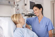 Nurse comforting patient in hospital bed