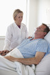 Doctor comforting patient in hospital bed