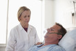 Doctor comforting patient in hospital bed