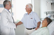 Doctor talking to patient's husband in hospital room