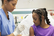 Nurse giving girl injection in hospital