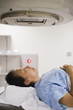Asian woman laying on x-ray table