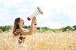 Foto: Woman with megaphone in the wheat field Woman with megaphone in the wheat field