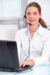 Young secretary with headphones and microphone