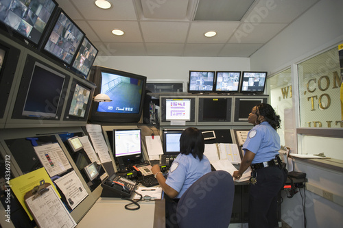 Photo: African American security guards working in control room African American security guards working in control room