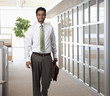 Businessman carrying briefcase in office