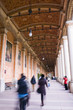 People walking underneath ornate portico
