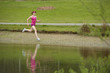 Mixed race woman running near pond