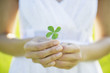 Hispanic woman holding four-leaf clover