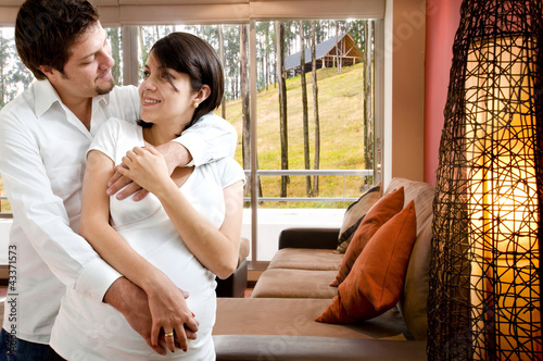Photo: young happy pregnant couple at new department young happy pregnant couple at new department
