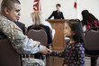 Soldier shaking girl's hand at political gathering