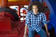 Foto: Mixed race teenager sitting on machinery Mixed race teenager sitting on machinery