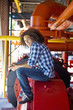 Foto: Mixed race teenager sitting on machinery Mixed race teenager sitting on machinery