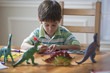 Hispanic boy sitting at table drawing