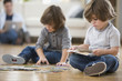 Mixed race brothers putting together puzzle on floor