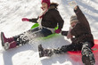 Hispanic girls sledding on snow covered hill